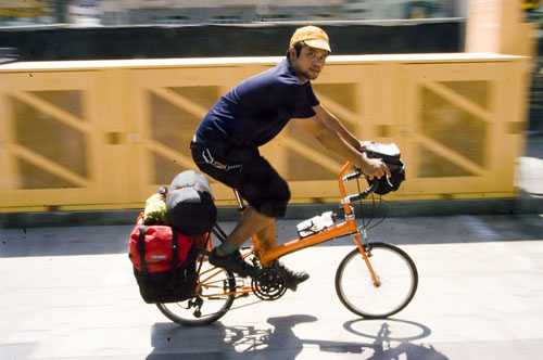Cyclist with camping gear riding toward state park campground on S24O overnight bicycle camping adventure