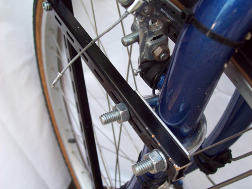 9. Use clear mineral oil to help the tubing slide onto the large U bolts. Cut it so that it does not extend onto the threads. Hold a piece of shelf rod near so that you can mark the location of the drill holes and cuts. Put the metal cross piece that came with the U bolts against the fork; I put the label touching the fork/paint.