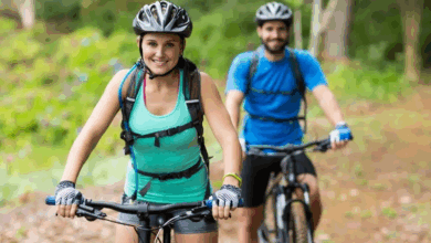 Does cycling burn belly fat? A couple riding their bikes along a forest trail, enjoying an active outdoor workout.