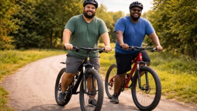 Two riders on best bikes for heavy riders cruising park bicycle path on high-capacity mountain bikes