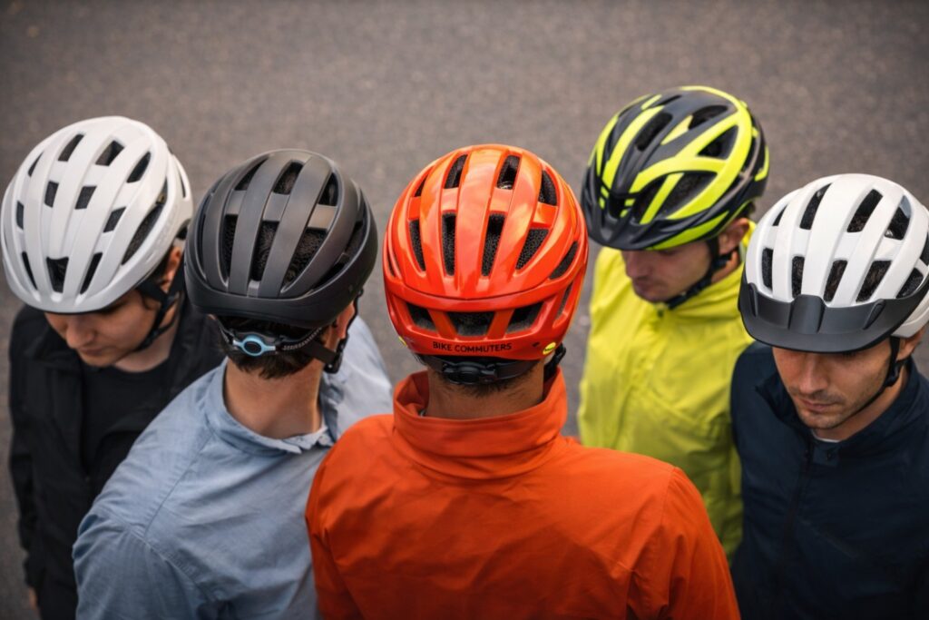 Various bike helmets displayed showing different styles, ventilation systems, and adjustment features