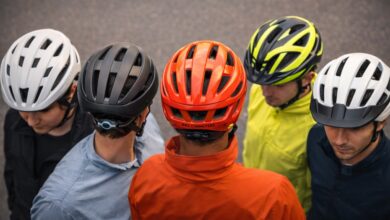 Various bike helmets displayed showing different styles, ventilation systems, and adjustment features