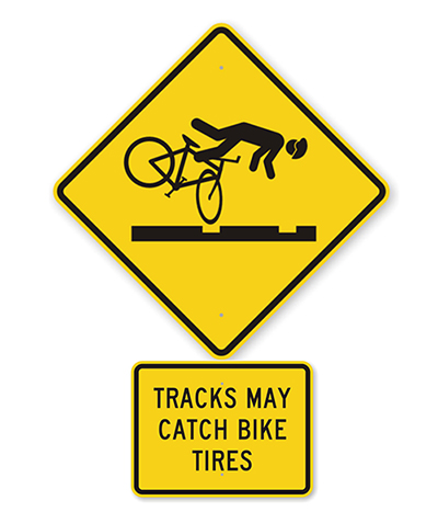 Bicycle-specific track warning sign warning that tracks may catch bike tires, an example of local cycling safety signs